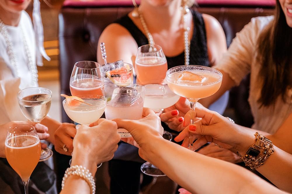 Personnes qui trinquent avec des cocktails à la main